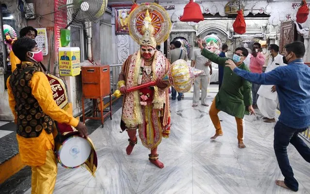 Indian man dress as lord Hanuman as other dance and pray in Hamuman temple after places of worship were allowed to re-open with strict guidelines in New Delhi, India, 08 June 2020. Countries around the world have started to ease COVID-19 lock-down restrictions in an effort to restart their economies and help people in their daily routines after the outbreak of coronavirus pandemic. (Photo by EPA/EFE/Rex Features/Shutterstock)