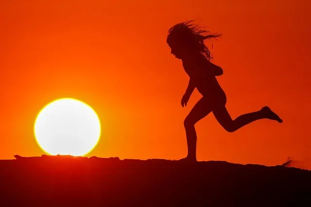 A child runs along the beach at sunset during the outbreak of the coronavirus disease (COVID-19) in Carlsbad, California, U.S., June 10, 2020. (Photo by Mike Blake/Reuters)