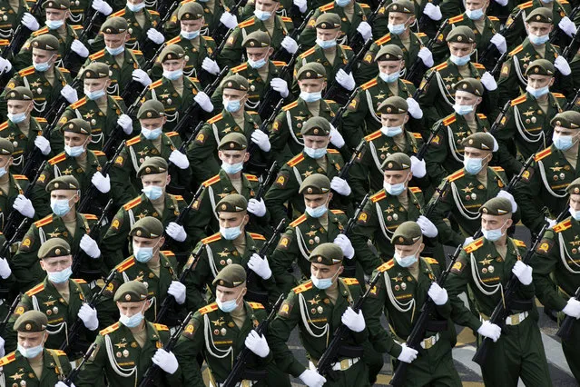 Russian soldiers wearing face masks to protect against coronavirus, march toward Red Square to attend a dress rehearsal for the Victory Day military parade in Moscow, Russia, Saturday, June 20, 2020. The military parade marking the 75th anniversary of the Nazi defeat was postponed from May 9 due to the outbreak of the coronavirus pandemic and is now set to take place on June 24. (Photo by Alexander Zemlianichenko/AP Photo)