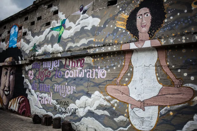 Graffitis, show a portrait of an old woman and a woman performing yoga, are seen in Medellin, Colombia on November 19, 2017. (Photo by Juancho Torres/Anadolu Agency/Getty Images)