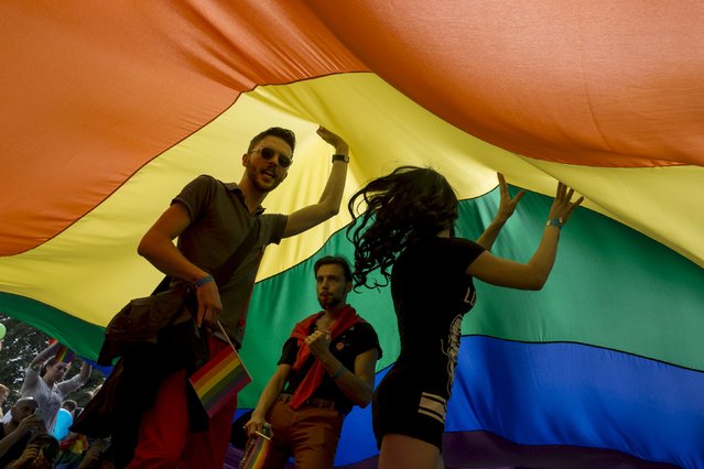 Participants dance under a rainbow flag during the annual gay pride parade march in Belgrade, Serbia, September 20, 2015. (Photo by Marko Djurica/Reuters)