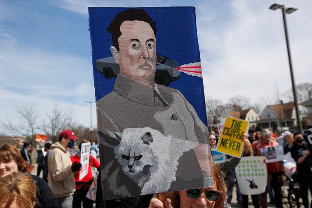 Demonstrators gather to protest President Donald Trump and Elon Musk while across the street from a Tesla car dealership in Providence, Rhode Island on Saturday March 22, 2025. President Trump recently signed an executive order aimed at dismantling the Department of Education while Elon Musk, who is the CEO of Tesla, has made significant financial and personnel cuts to several government agencies after being appointed to run the Department of Government Efficiency or DOGE. (Photo by Matthew Healey/UPI/Rex Features/Shutterstock)