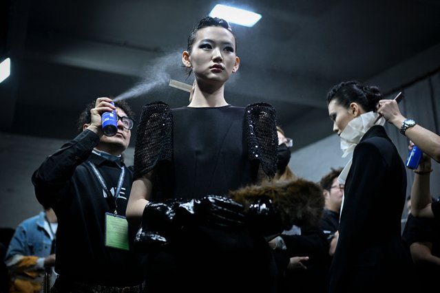 A model prepares backstage before the Shengze Fashion show collection by Qi Gang during China Fashion week in Beijing on March 26, 2025. (Photo by Wang Zhao/AFP Photo)