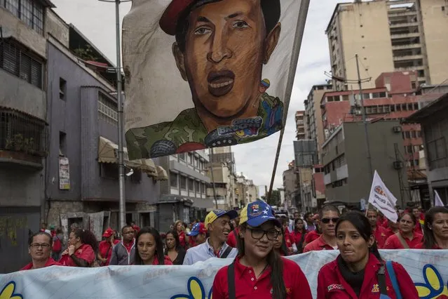 People march with a banner of Venezuela's late former president Hugo Chavez, in support of President Nicolas Maduro, in downtown in Caracas, Venezuela, Wednesday, October 25, 2017. (Photo by Rodrigo Abd/AP Photo)