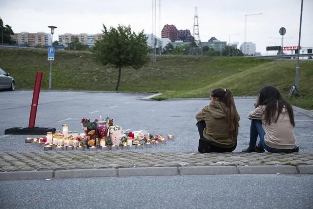 Flowers and candles are placed Sunday August 2, 2020 near where a twelve-year-old girl was shot and killed near a petrol station in Botkyrka, south of Stockholm, Sweden. (Photo by Ali Lorestani/TT via AP Photo)