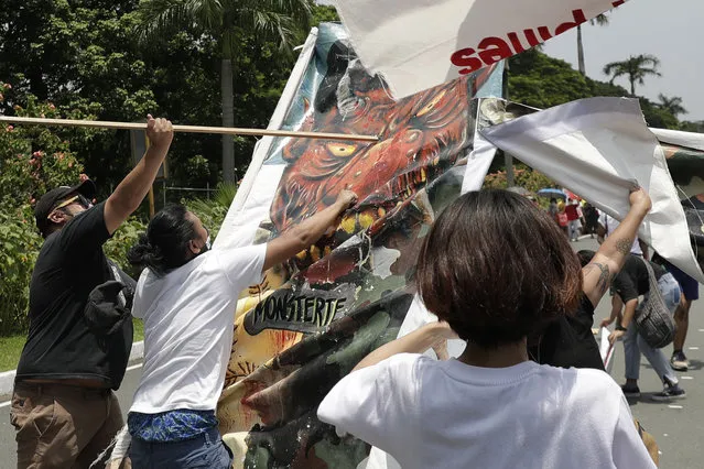 Protesters hit a caricature of Philippine President Rodrigo Duterte as they hold a rally in time for his State of the Nation Address on Monday, July 27, 2020 in Manila, Philippines. Hundreds of protesters marched, staged motorcades and held a rally against a new anti-terror law and other issues Monday in the Philippine capital despite police threats of arrests ahead of the president’s annual state of the nation speech. (Photo by Aaron Favila/AP Photo)
