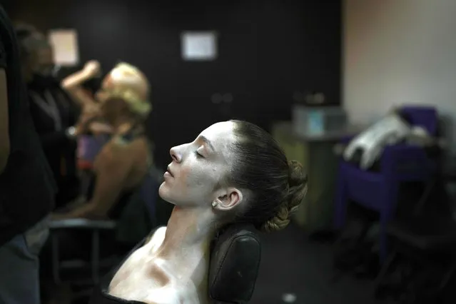 A dancer pauses while putting on make up in preparation for the pre premiere of “The Nutcracker” ballet at the Teresa Carreno Theater in Caracas, Venezuela, Thursday, December 8, 2022. (Photo by Ariana Cubillos/AP Photo)