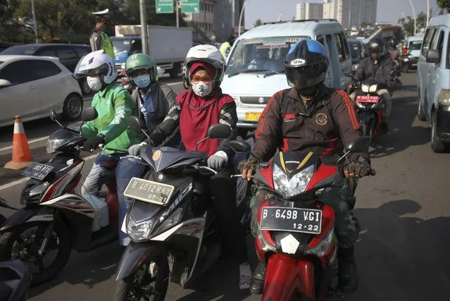 Motorists are seen wearing masks as a precaution against the coronavirus outbreak during rush hour traffic in Jakarta, Indonesia, Monday, September 21, 2020. (Photo by Dita Alangkara/AP Photo)
