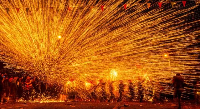 Folk artists play “iron flowers”, a performance of splashing molten iron to create fireworks, in celebration of the upcoming Latern Festival at Goujiang Township of Bozhou District, Zunyi City of southwest China's Guizhou Province, January 30, 2023. The Lantern Festival, the 15th day of the first month of the Chinese lunar calendar, falls on Feb. 5 this year. The festival features family reunions, feasts, light shows and various cultural activities. (Photo by Xinhua News Agency/Rex Features/Shutterstock)