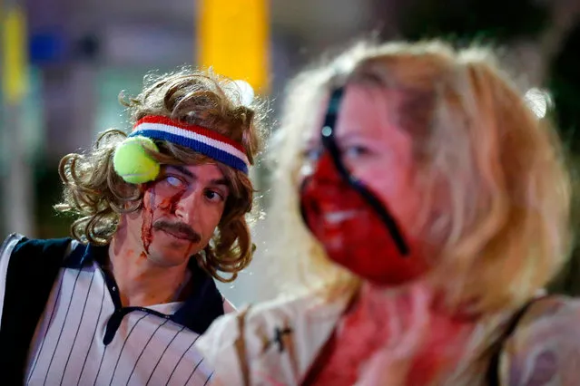 People wearing costumes and face paint take part in a “Zombie walk” in Tel Aviv as part of the Jewish holiday of Purim on March 3, 2018. The carnival- like Purim holiday is celebrated with parades and costume parties to commemorate the deliverance of the Jewish people from a plot to exterminate them in the ancient Persian empire 2,500 years ago, as described in the Book of Esther. (Photo by  Jack Guez/AFP Photo)