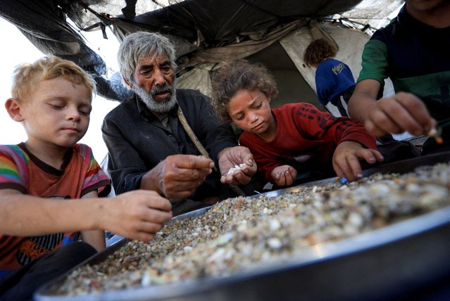 Displaced Palestinians who have not received humanitarian aid gather as they survive on leftover food, amid a hunger crisis, in Gaza, on July 28, 2025. (Photo by Dawoud Abu Alkas/Reuters)