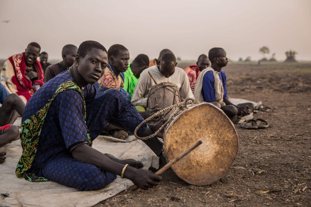 Sudanese cattle herders from Dinka tribe gather their church' s prayer in the early morning at their cattle camp in Mingkaman, Lakes State, South Sudan on March 4, 2018. (Photo by  Stefanie Glinski/AFP Photo)