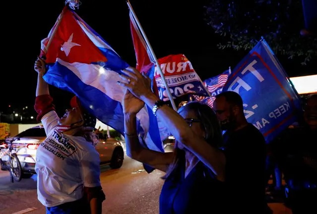 A supporter of U.S. President Donald Trump holds a Cuban flag during the 2020 U.S. presidential election, in Miami, Florida, U.S., November 3, 2020. (Photo by Marco Bello/Reuters)
