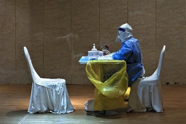 A medical worker in protective gear waits to administer COVID-19 tests for reporters who was signed up to cover the press conference and the opening of the Chinese People's Political Consultative Conference (CPPCC), at a quarantine hotel in Beijing, Thursday, March 2, 2023. The annual meeting of China's National People's Congress, the country's top legislative body, kicks off in Beijing on Sunday. (Photo by Andy Wong/AP Photo)