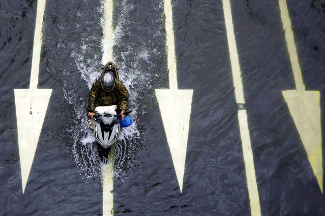 A rider drives his motorcycle along a flooded road following tropical storm Wipha fueled monsoon rains in Manila, Philippines on Tuesday, July 22, 2025. (Photo by Aaron Favila/AP Photo)