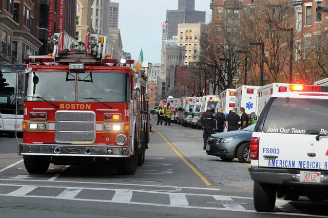 A long line of ambulances wait in a staging area after explosions rocked the finish area of the Boston Marathon on April 15, 2013 in Boston, Massachusetts.  At least two people were killed and 22 wounded when two explosions struck near the finish line of the Boston Marathon, sparking scenes of panic, police said. The streets were littered with debris and blood and paramedics raced off with stretchers as police locked down the area, witness said. TV footage showed an explosion sending up a white plume of smoke along the sidelines of the race. (Photo by John Mottern/AFP Photo)