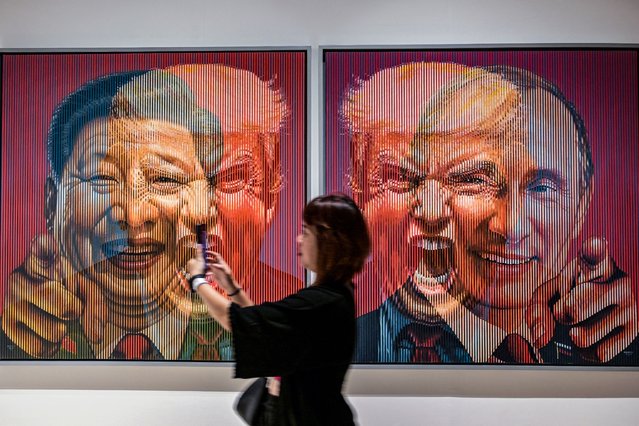 A visitor stands near an art installation portraying China's President Xi Jinping, U.S. President Donald Trump and Russia's President Vladimir Putin during the ARTSUBS exhibition in Surabaya, Indonesia on August 2, 2025. (Photo by Juni Kriswanto/AFP Photo)