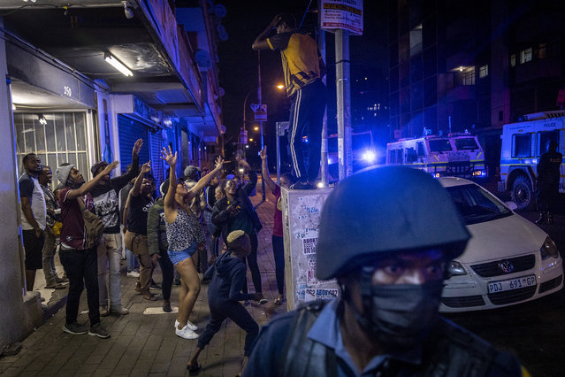 People party as police patrol in Hillbrow, Johannesburg after midnight January 1 2022. This follows the lifting of the twelve to four curfew and other COVID-19 restrictions. (Photo by Shiraaz Mohamed/AP Photo)