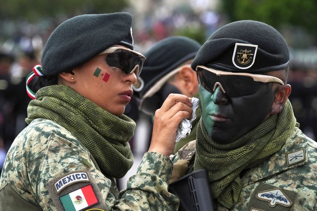 Soldiers adjust their face paint during the annual Independence Day parade in Mexico City, Tuesday, September 16, 2025. (Photo by Fernando Llano/AP Photo)