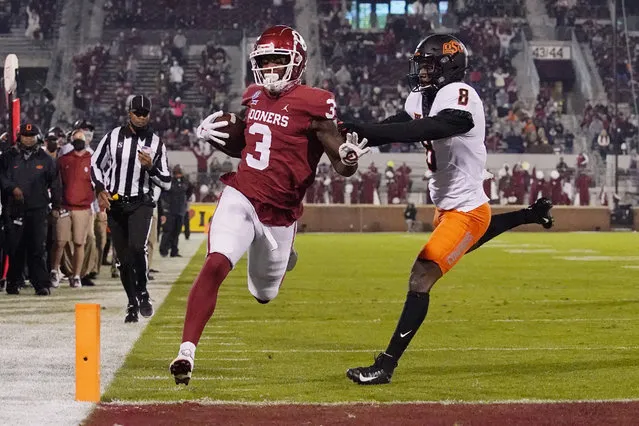 Oklahoma tight end Mikey Henderson (3) carries for a touchdown past Oklahoma State defender Rodarius Williams (8) during the first half of an NCAA college football game in Norman, Okla., Saturday, November 21, 2020. (Photo by Sue Ogrocki/AP Photo)