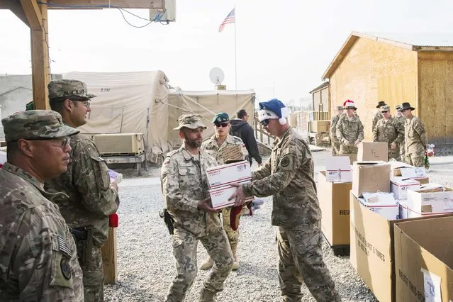 U.S. soldiers from the 3rd Cavalry Regiment pass out care packages and Christmas stockings to fellow soldiers and workers on forward operating base Gamberi in the Laghman province of Afghanistan December 24, 2014. (Photo by Lucas Jackson/Reuters)