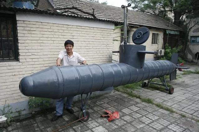 Tao Xiangli stands beside his homemade submarine in a courtyard in Beijing July 10, 2008. The amateur inventor says his submarine is made from old oil barrels but fully functional with a periscope, depth control tanks, electric motors and two propellers. (Photo by Reinhard Krause/Reuters)