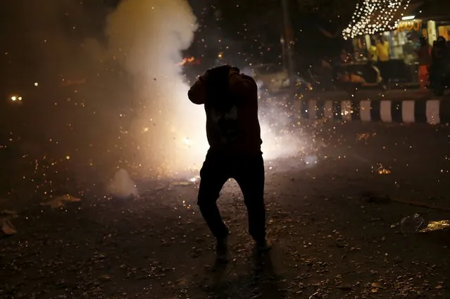 A man tries to protect himself from firecrackers while celebrating the Hindu festival of Diwali, the annual festival of lights in New Delhi, India, November 11, 2015. (Photo by Adnan Abidi/Reuters)