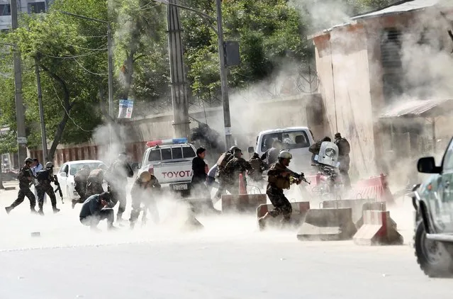 Security forces run from the site of a suicide attack after the second bombing in Kabul, Afghanistan, Monday, April 30, 2018. A coordinated double suicide bombing hit central Kabul on Monday morning, (Photo by Massoud Hossaini/AP Photo)