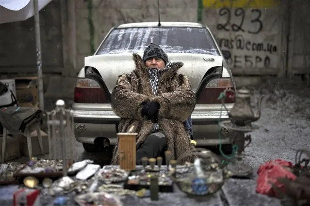 A vendor sits at a flea market in Kyiv, Ukraine, Saturday, February 4, 2023. (Photo by Daniel Cole/AP Photo)