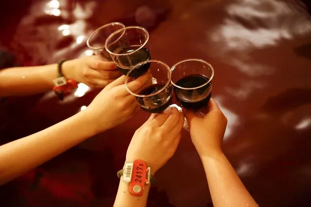 Women clink wine glasses as they sit in a hot bath with coloured water representing wine at the Hakone Kowaki-en Yunessun spa resort during an event marking Beaujolais Nouveau Day in Hakone west of Tokyo, November 19, 2015. (Photo by Thomas Peter/Reuters)