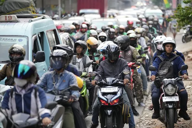 People ride motorcycles to their home village, leaving from Jakarta, Indonesia, Wednesday, April 19, 2023. The mass exodus out of Jakarta and other major cities in the world's most populous Muslim country is underway as millions are heading home to their villages to celebrate Eid al-Fitr holiday that marks the end of the holy fasting month of Ramadan. (Photo by Achmad Ibrahim/AP Photo)