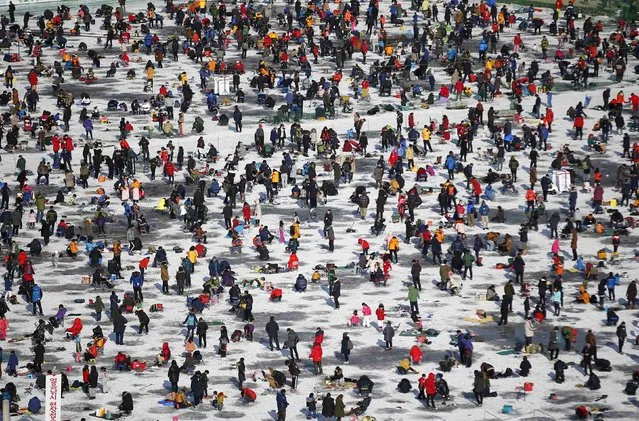 People take part in ice fishing on a frozen river in Hwacheon, about 20 km (12 miles) south of the demilitarized zone separating the two Koreas, January 10, 2015. (Photo by Kim Hong-Ji/Reuters)