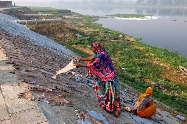 Women dry cattle hides outside of a tannery by the Dhaleshwari river, which feeds into the Buriganga river, in Savar, on the outskirts of Dhaka, Bangladesh, March 7, 2023. (Photo by Mohammad Ponir Hossain/Reuters)