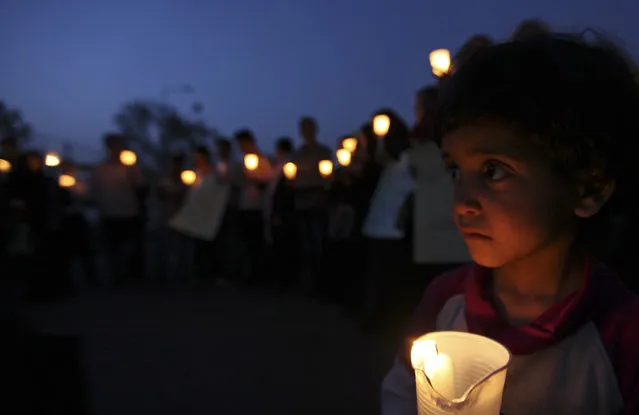 A boy holds a candle during a candlelight vigil to condemn a suicide attack that killed over 100 soldiers in Sanaa May 28, 2012. (Photo by Mohamed al-Sayaghi/Reuters)