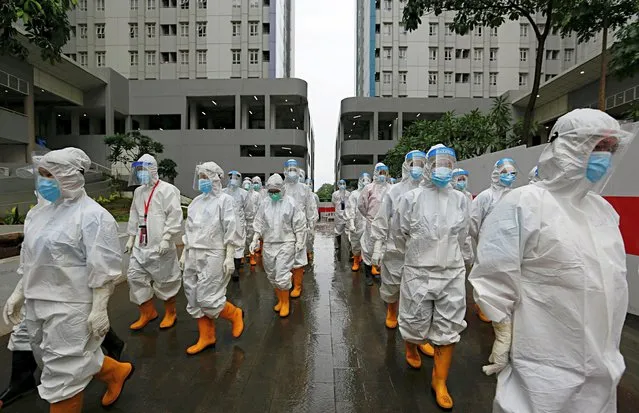Healthcare workers wearing personal protective equipment (PPE) prepare to treat patients at the emergency hospital for coronavirus disease (COVID-19) in Athletes Village, Jakarta, Indonesia on January 26, 2021. (Photo by Ajeng Dinar Ulfiana/Reuters)