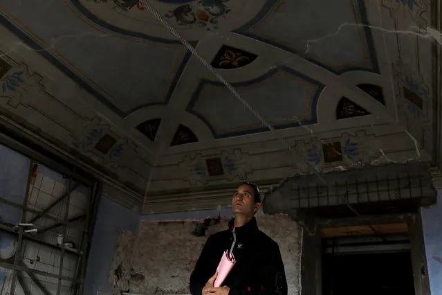 Luca Cucchiella looks at historical frescoes on the ceiling of a room in his familyÕs house, which is undergoing restoration after being damaged during the 2009 earthquake, in Santo Stefano di Sessanio in the province of L'Aquila in Abruzzo, inside the national park of the Gran Sasso e Monti della Laga, Italy, September 23, 2016. (Photo by Siegfried Modola/Reuters)