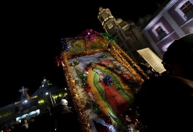 A pilgrim holds up an image of the Virgin of Guadalupe inside the Basilica of Guadalupe during the annual pilgrimage in honor of the Virgin of Guadalupe, patron saint of Mexican Catholics, in Mexico City, Mexico December 12, 2015. (Photo by Henry Romero/Reuters)