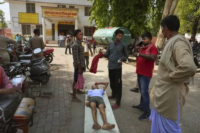 An elderly person suffering from heat related ailment lies on a stretcher waiting to get admitted outside the overcrowded government district hospital in Ballia, Uttar Pradesh state, India, Monday, June 19, 2023. (Photo by Rajesh Kumar Singh/AP Photo)