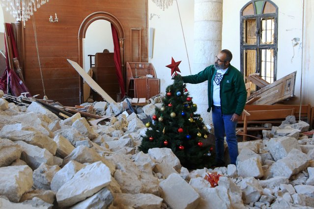 A man sets up a Christmas tree amidst the rubble of the Melkite Church, which hit by an Israeli airstrike on October 9, in the southern Lebanese village of Derdghaya on December 20, 2024 (Photo by Mahmoud Zayyat/AFP Photo)