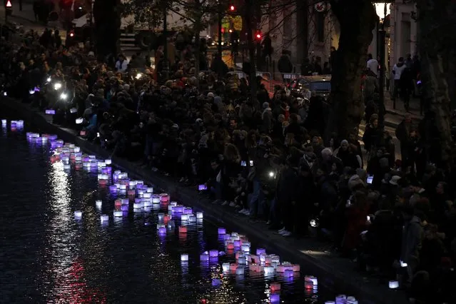 People release floats lit with candles on the Canal Saint-Martin, in Paris, France, November 13, 2016, after ceremonies held for the victims of last year's Paris attacks which targeted the Bataclan concert hall as well as a series of bars and killed 130 people. (Photo by Benoit Tessier/Reuters)