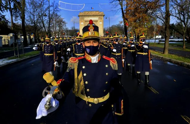 Soldiers of to the Romanian Presidential Honor Guard wearing protection masks march in front of the Triumph Arch during a small ceremony organized to mark Romania's Great Union Day, in Bucharest, Romania, 01 December 2020. Due to the COVID-19 pandemic safety reasons, the event that was marked in recent years with a big military parade, was restricted to a small ceremony without public. Romania is celebrating Great Union Day which commemorates the unification of the three historical provinces of Transylvania, Basarabia and Bucovina with Romania in 1918. (Photo by Robert Ghement/EPA/EFE)