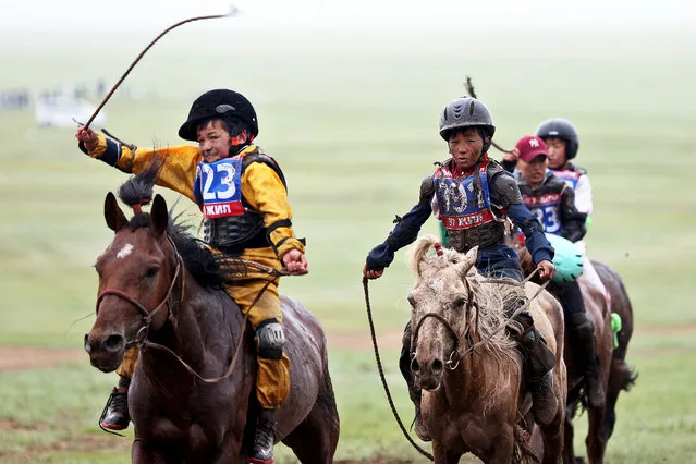 Child jockeys riding horses arrive to the finish line during a horse race at the Mongolian traditional Naadam festival, on the outskirts of Ulaanbaatar, Mongolia July 11, 2018. (Photo by Rentsendorj Bazarsukh/Reuters)