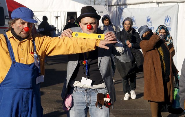 Members of Red Noses Clowndoctors entertain migrants before their departure to Austria at a registration center in Dobova, Slovenia, December 27, 2015. (Photo by Srdjan Zivulovic/Reuters)