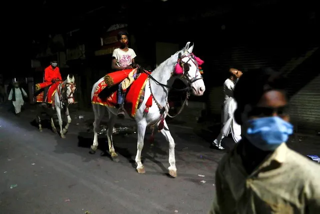 People ride horses on a street during a curfew to limit the spread of the coronavirus disease (COVID-19), in New Delhi, India, April 6, 2021. (Photo by Adnan Abidi/Reuters)
