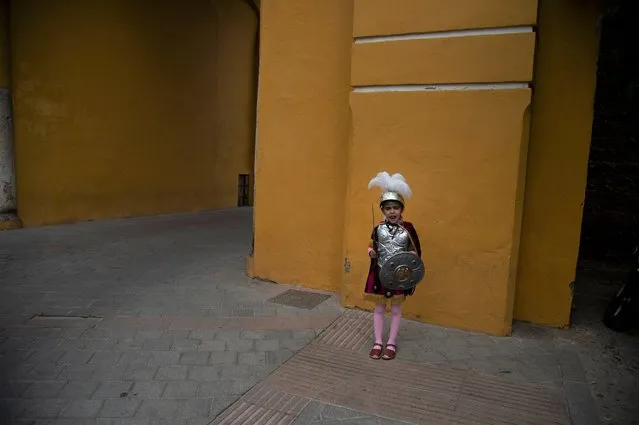 A child dressed up with the Macarena brotherhood's “Armao” uniform plays at the Macarena arch close to La Macarena Basilica, in Seville on April 1, 2021. 2021 is the second consecutive year cancellating Holy Week processions' in Seville due to the coronavirus pandemic. (Photo by Cristina Quicler/AFP Photo)