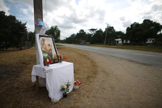 A table with a photograph of Cuba's former President Fidel Castro stands next to the road where Castro's ashes are to pass during a journey to the eastern city of Santiago de Cuba, in Cascorro, Cuba, December 2, 2016. (Photo by Alexandre Meneghini/Reuters)