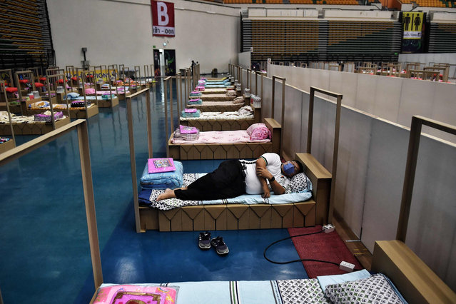 A Bangkok Metropolitan Administration worker tests a bed for incoming Covid-19 coronavirus patients at a new field hospital in a sports stadium on the outskirts of Bangkok on April 18, 2021. (Photo by Lillian Suwanrumpha/AFP Photo)