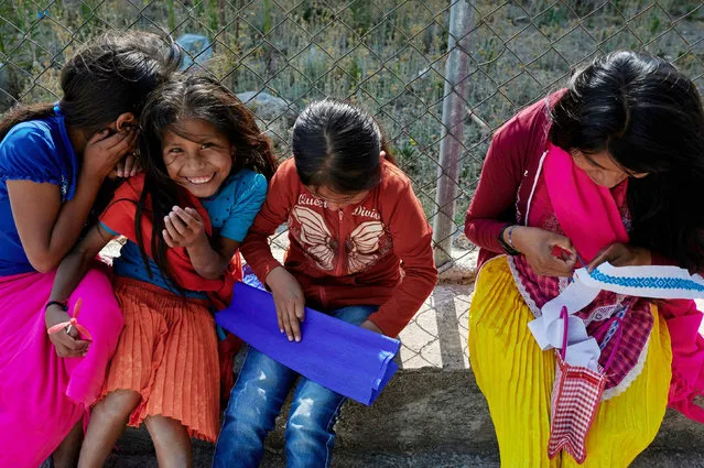 Women and children of the Nahua indigenous community of Alcozacan make pinatas, before a demonstration with children carrying replicas of toy and wooden weapons, in the town of Alcozacan, Guerrero, Mexico on April 29, 2021. (Photo by Mahe Elipe/Reuters)