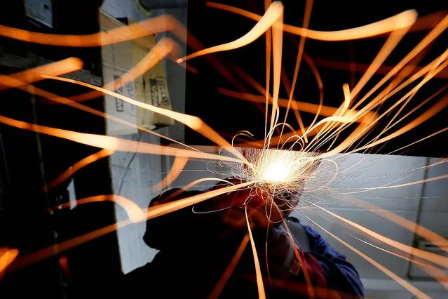 Worker Barry Smith grinds the base of a “Spirit of Ecstasy”. (Photo by Stefan Wermuth/Reuters)