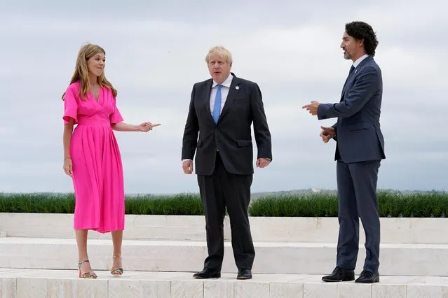 Britain's Prime Minister Boris Johnson (C), his spouse Carrie Johnson (L) and Canada's Prime Minister Justin Trudeau talk during the G7 summit in Carbis Bay, Cornwall, south-west England on June 11, 2021. (Photo by Patrick Semansky/Pool via AFP Photo)